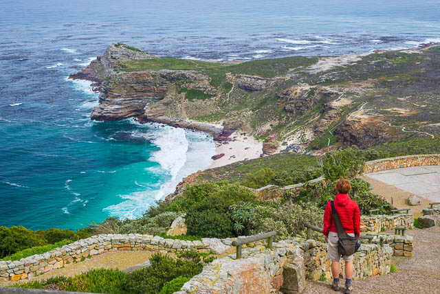 tourist hiking at cape point looking at view of cape of good hope and dias beach, south africa