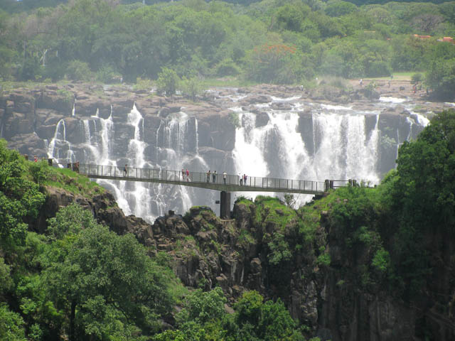 tourists enjoying victoria falls from knife edge bridge in livingstone, zambia