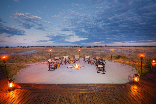 chairs laid around campfire looking over nxai pan national park