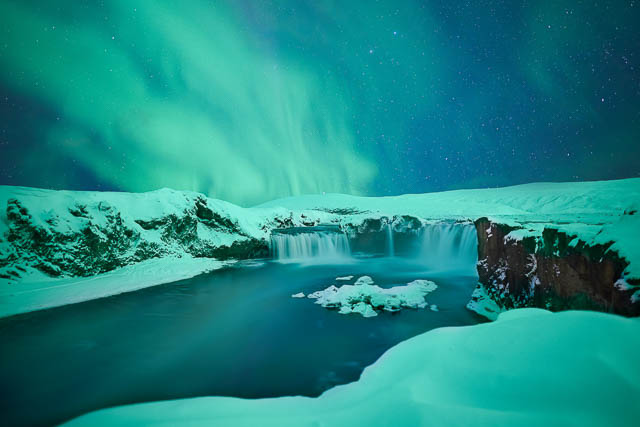 northern lights above godafoss falls iceland