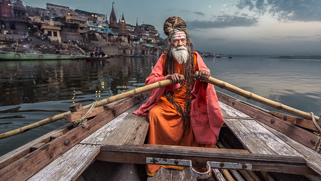 a sage riding a boat in ganga river varanasi india