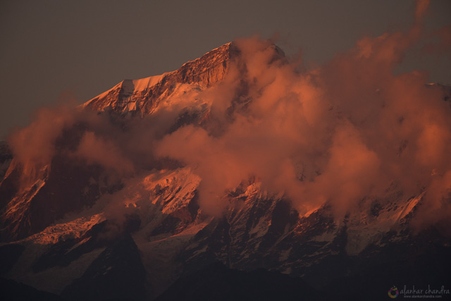 golden shadow falls on one of himalayas peak surrounded by clouds chopta uttarakhand india