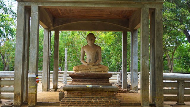 green surrounding encompasses the samadhi buddha statue in anuradhapura, sri lanka