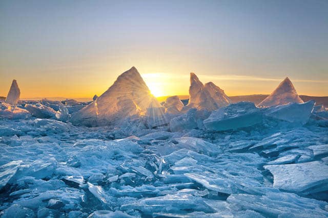 lots of pieces of ice and hummocks with reflection on lake baikal in siberia at sunset